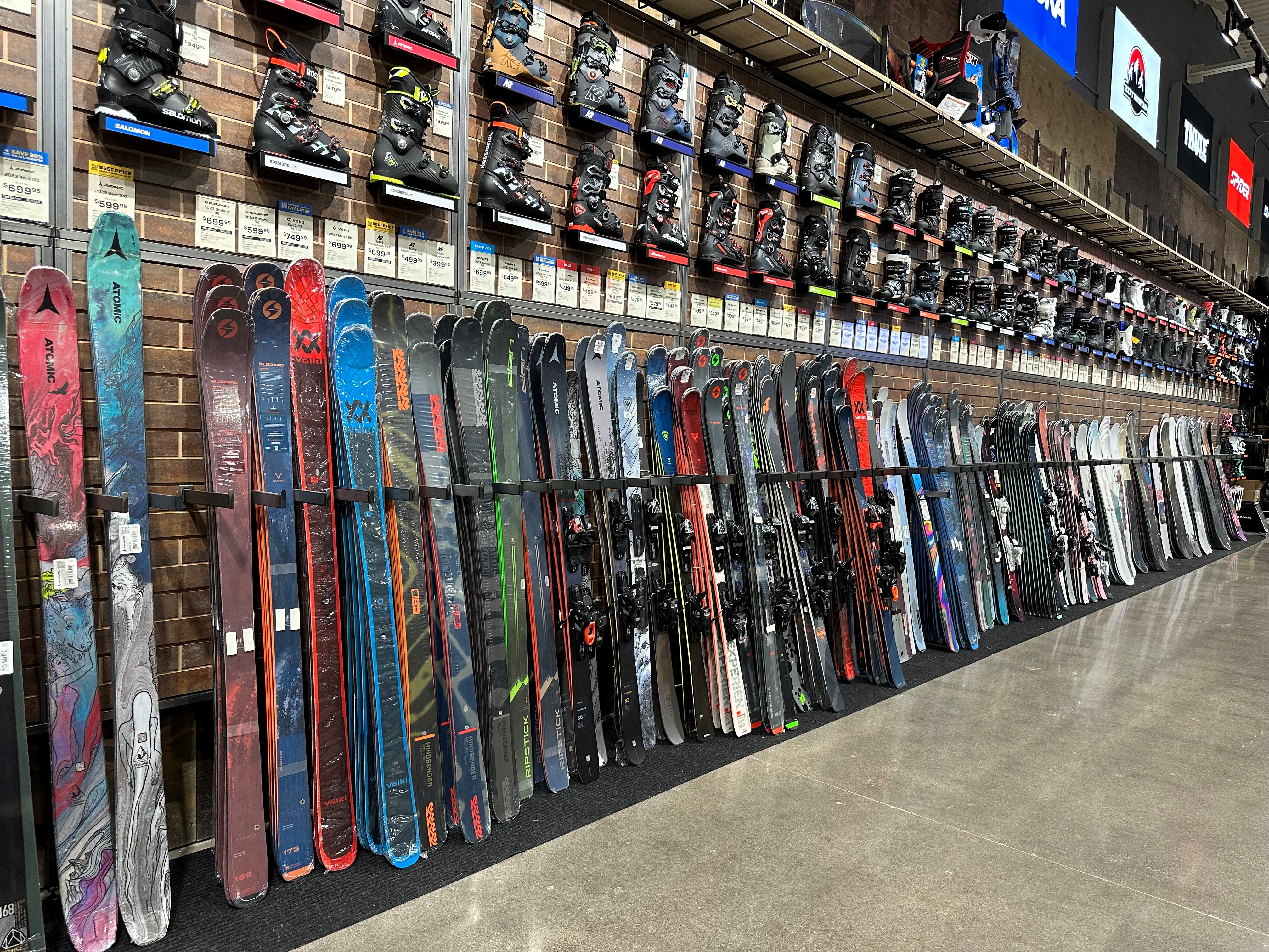 Wall of skis and ski boots at a Sun & Ski Sports shop in Phoenix, Arizona.